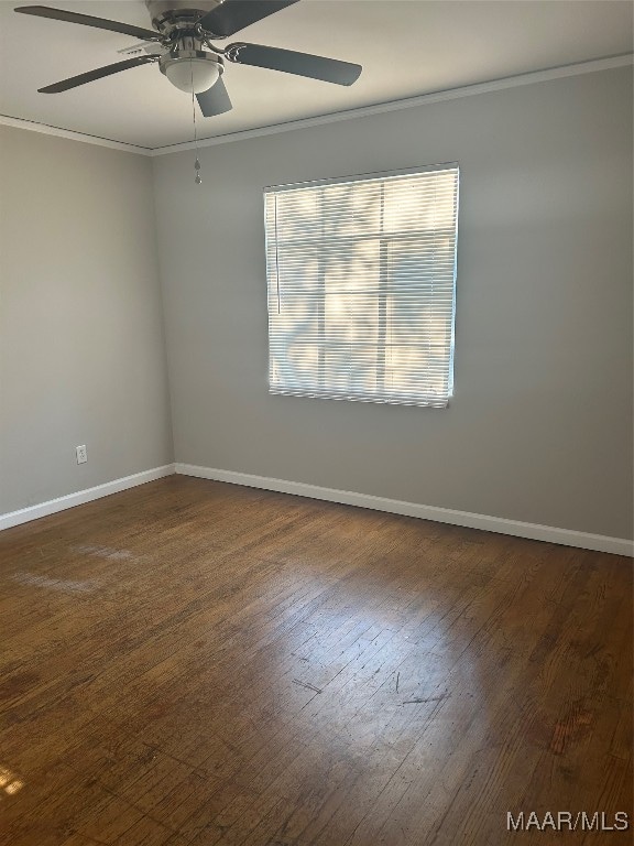 unfurnished room featuring ceiling fan, dark wood-type flooring, and crown molding