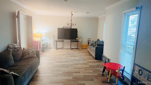 living room with crown molding, a notable chandelier, and light hardwood / wood-style floors