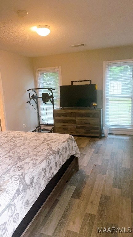 bedroom featuring a textured ceiling and hardwood / wood-style flooring