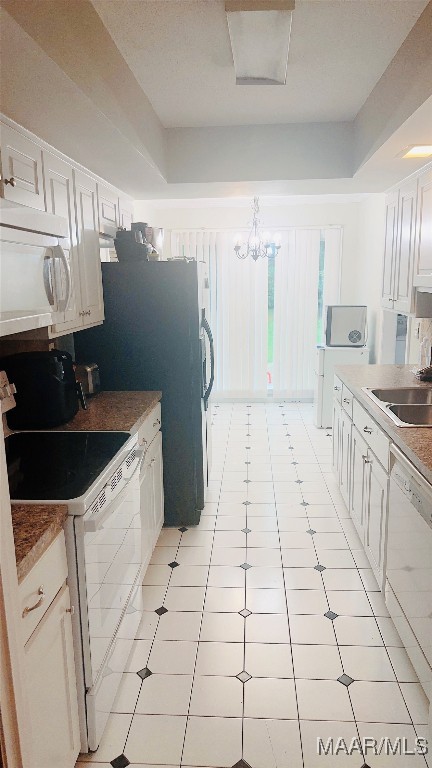 kitchen featuring light tile patterned floors, an inviting chandelier, white appliances, white cabinetry, and sink