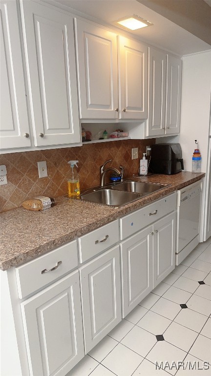 kitchen featuring white dishwasher, sink, white cabinetry, and tasteful backsplash