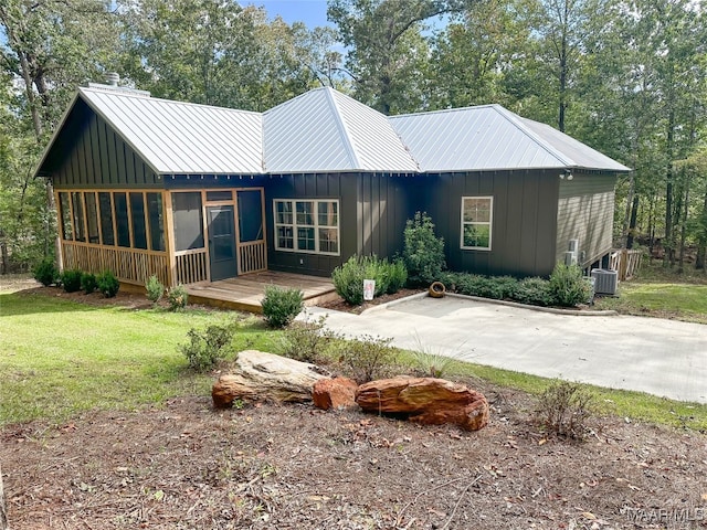 exterior space with a lawn and central AC