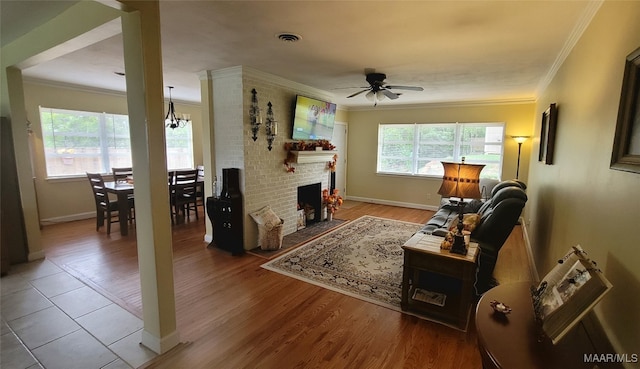 living room featuring ceiling fan, a brick fireplace, and hardwood / wood-style flooring