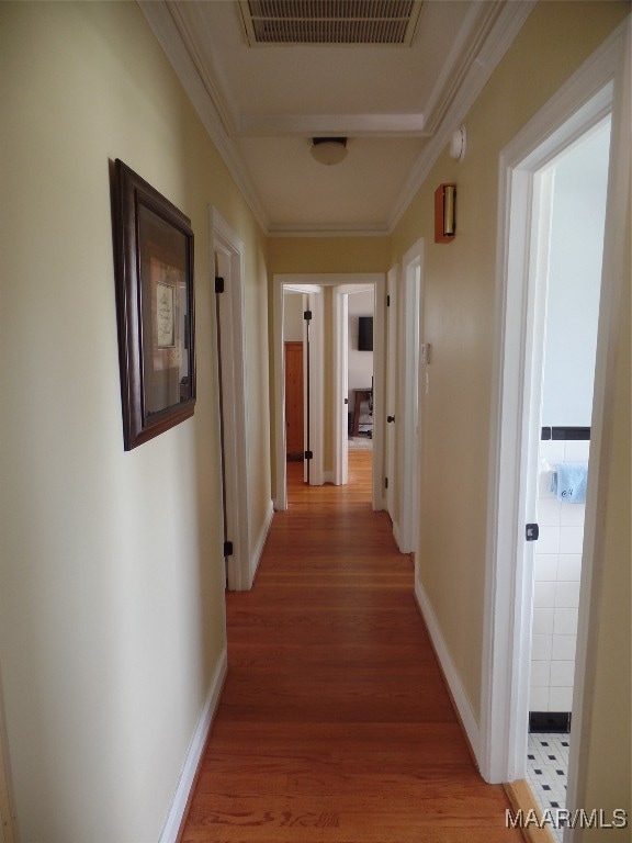 hallway featuring ornamental molding and hardwood / wood-style floors