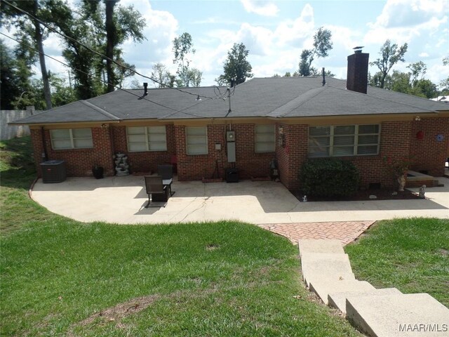 ranch-style house featuring a front lawn, central AC unit, and a patio area