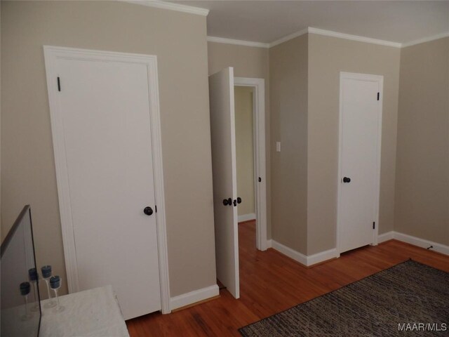 unfurnished bedroom with wood-type flooring, a closet, and ornamental molding