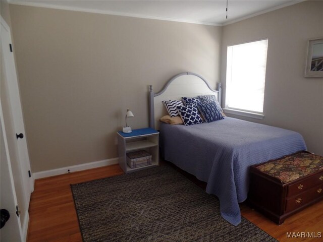 bedroom featuring dark hardwood / wood-style floors and ornamental molding