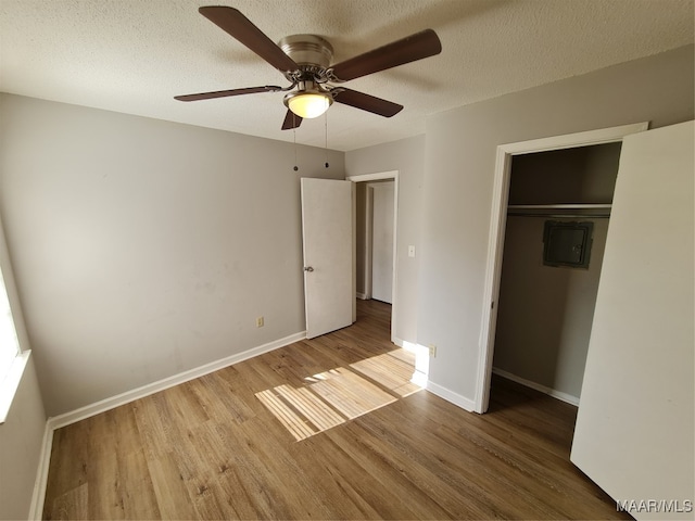 unfurnished bedroom with light hardwood / wood-style flooring, a closet, ceiling fan, and a textured ceiling