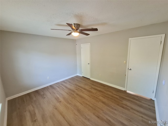 empty room featuring ceiling fan, hardwood / wood-style floors, and a textured ceiling