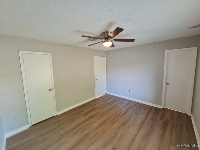 unfurnished bedroom with a textured ceiling, ceiling fan, and hardwood / wood-style flooring