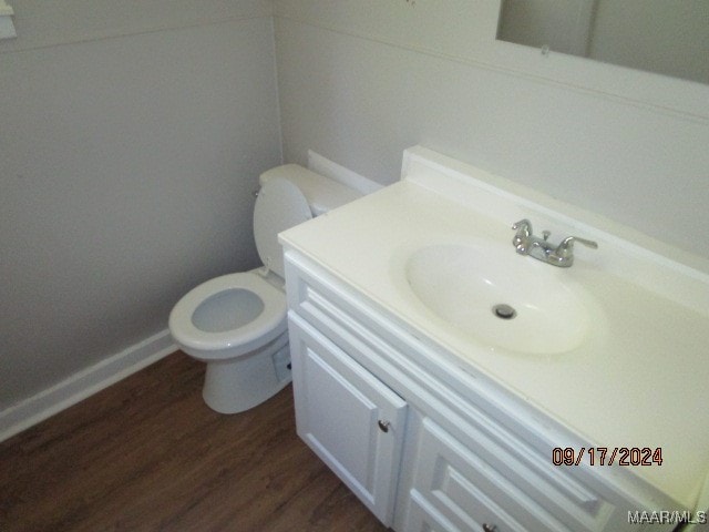 bathroom featuring wood-type flooring, vanity, and toilet