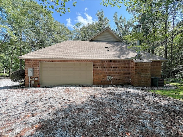 view of side of property featuring cooling unit and a garage