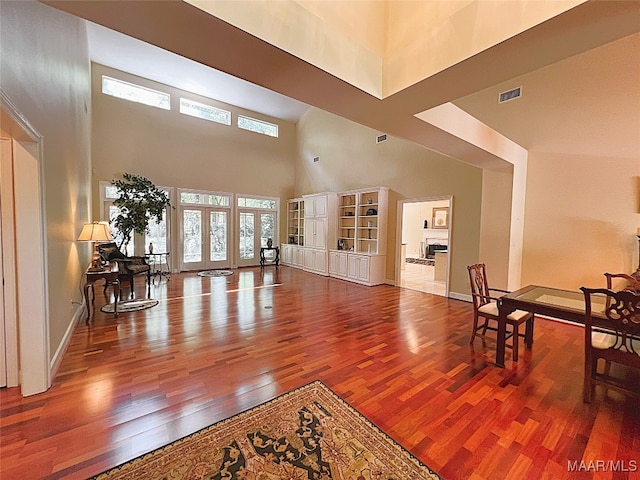 interior space featuring french doors, hardwood / wood-style floors, and a high ceiling