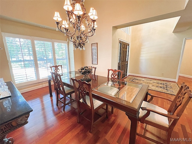 dining area featuring dark hardwood / wood-style floors and an inviting chandelier