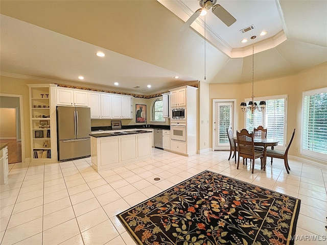 kitchen with appliances with stainless steel finishes, ceiling fan with notable chandelier, light tile patterned flooring, and white cabinetry