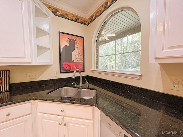 kitchen featuring dark stone countertops, white cabinets, crown molding, and sink