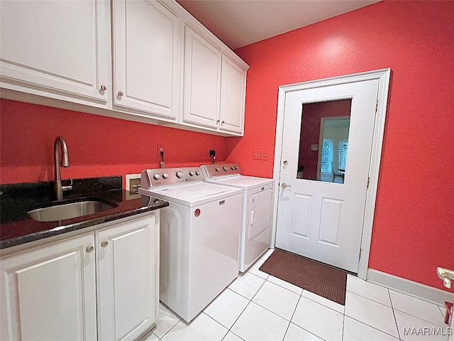 washroom featuring light tile patterned floors, sink, washer and dryer, and cabinets