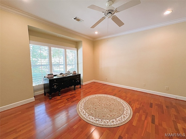 spare room with ceiling fan, crown molding, and wood-type flooring