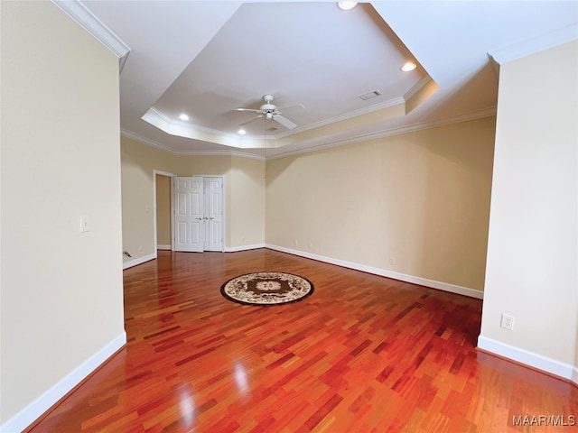 spare room with ceiling fan, hardwood / wood-style flooring, a tray ceiling, and ornamental molding