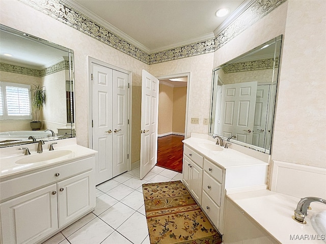 bathroom featuring a bathtub, tile patterned flooring, ornamental molding, and vanity