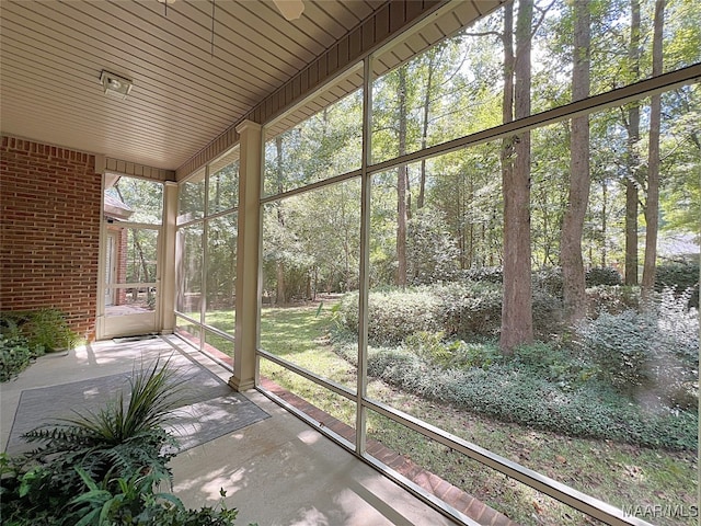 unfurnished sunroom with wood ceiling and a water view