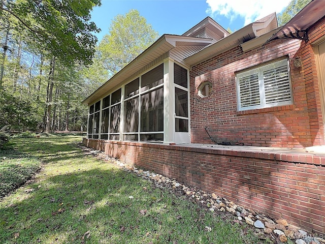 view of home's exterior with a lawn and a sunroom