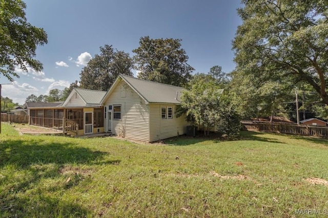 back of house featuring a sunroom, a yard, and cooling unit