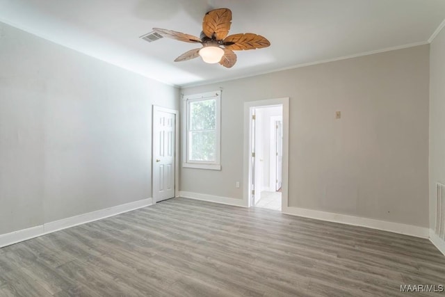 spare room with hardwood / wood-style flooring, ornamental molding, and ceiling fan