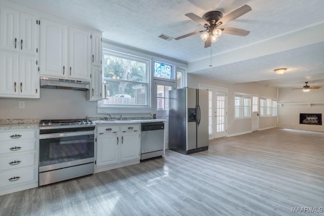 kitchen featuring white cabinets, a textured ceiling, appliances with stainless steel finishes, and sink