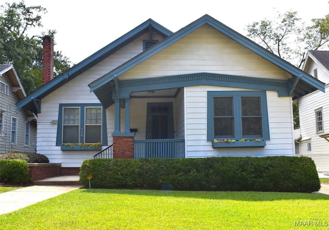 bungalow-style home with a front lawn and a porch