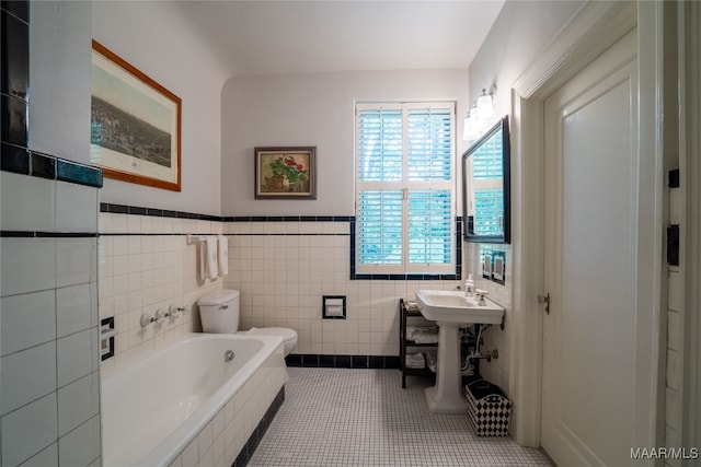 bathroom featuring a tub to relax in, toilet, tile walls, and tile patterned floors