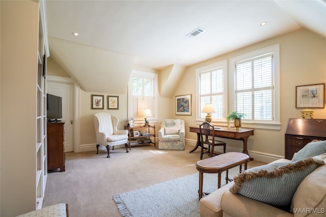 sitting room with lofted ceiling, light colored carpet, and a healthy amount of sunlight