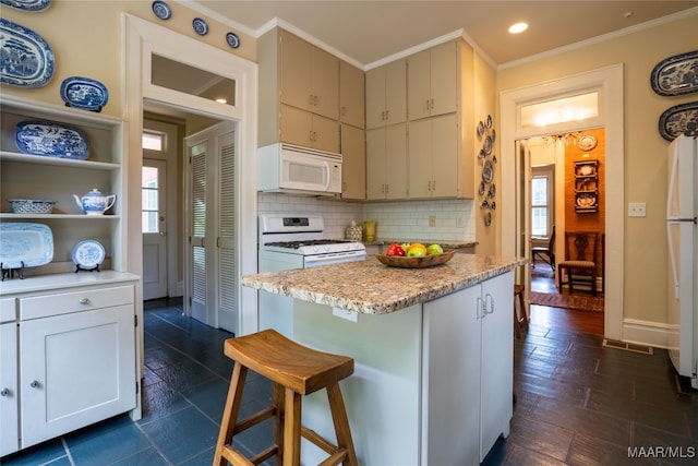 kitchen featuring white appliances, dark hardwood / wood-style flooring, plenty of natural light, and a breakfast bar