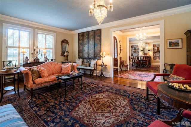 living room with wood-type flooring, crown molding, and a notable chandelier