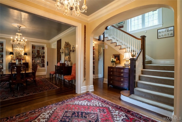 foyer featuring a notable chandelier, hardwood / wood-style floors, and crown molding