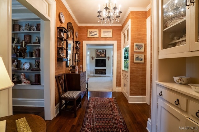 hallway featuring ornamental molding, a chandelier, and dark wood-type flooring