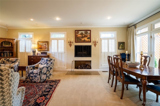 carpeted dining space featuring a healthy amount of sunlight and crown molding