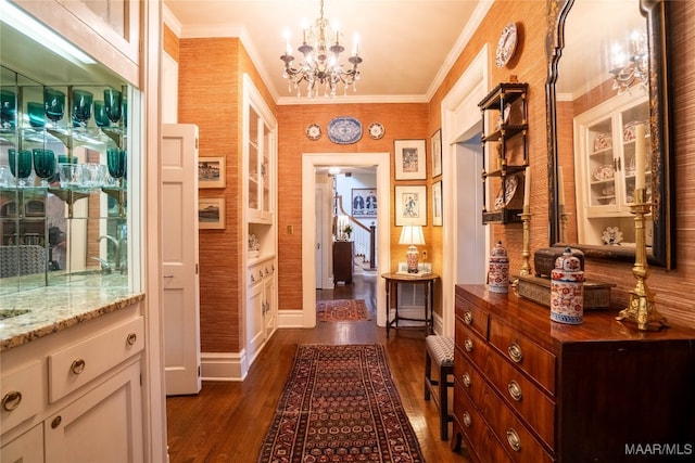 interior space featuring a notable chandelier, dark hardwood / wood-style floors, and ornamental molding