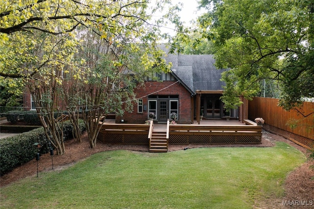 back of house featuring a lawn and a deck