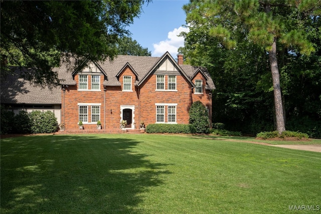 tudor-style house with a front yard