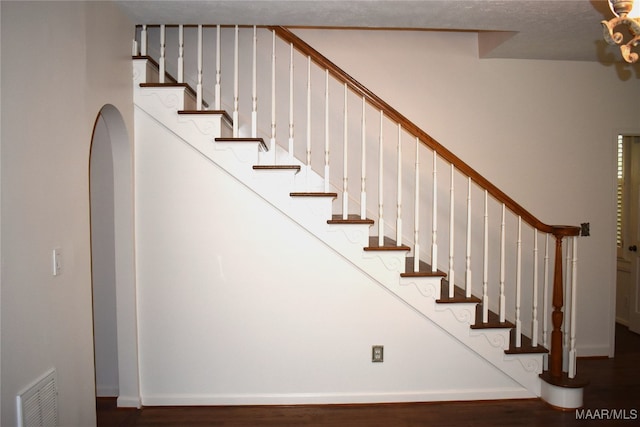 stairway with a textured ceiling and hardwood / wood-style flooring