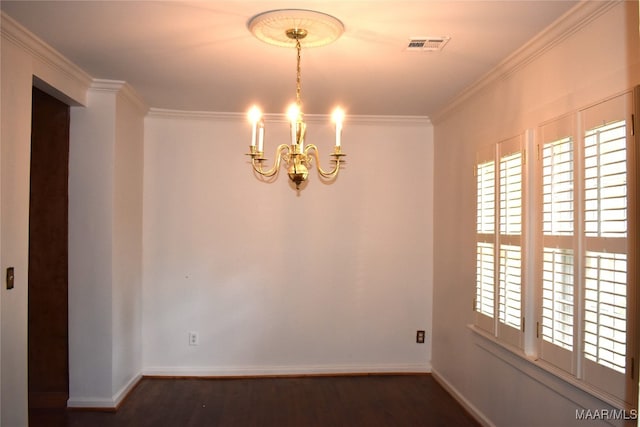 empty room with a chandelier, dark hardwood / wood-style floors, and crown molding