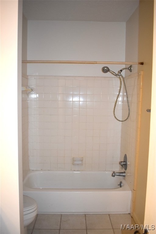 bathroom featuring tiled shower / bath combo, tile patterned floors, and toilet