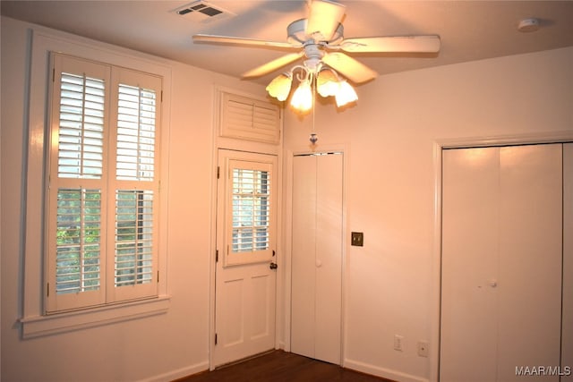 foyer entrance featuring ceiling fan and dark wood-type flooring