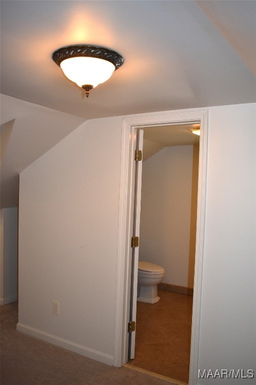 interior space featuring tile patterned flooring and vaulted ceiling