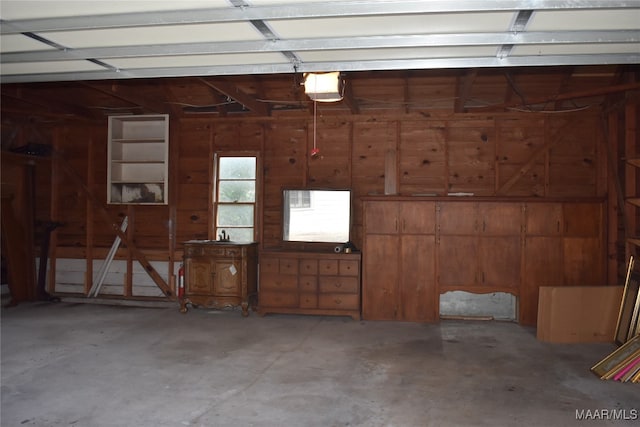 garage featuring a garage door opener and wood walls