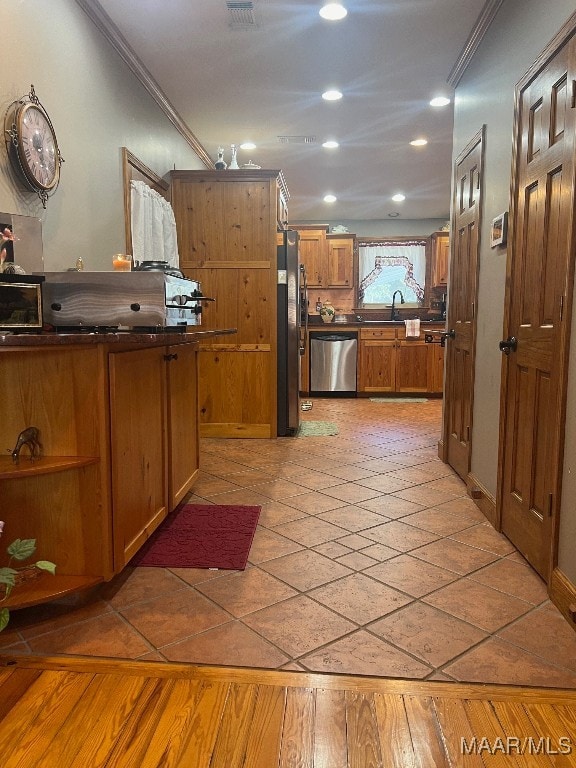 kitchen with ornamental molding, stainless steel appliances, and dark hardwood / wood-style floors