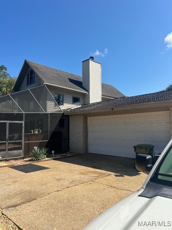 view of front of property featuring a garage and a lanai