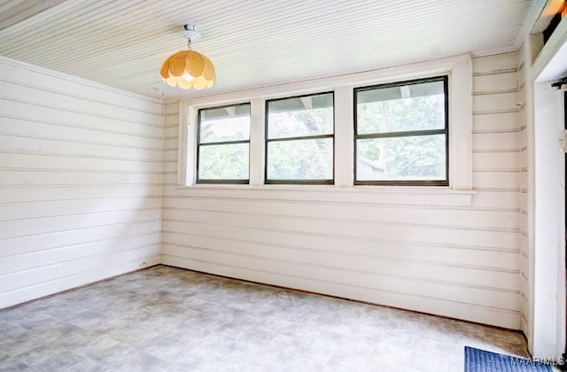 spare room with wood walls