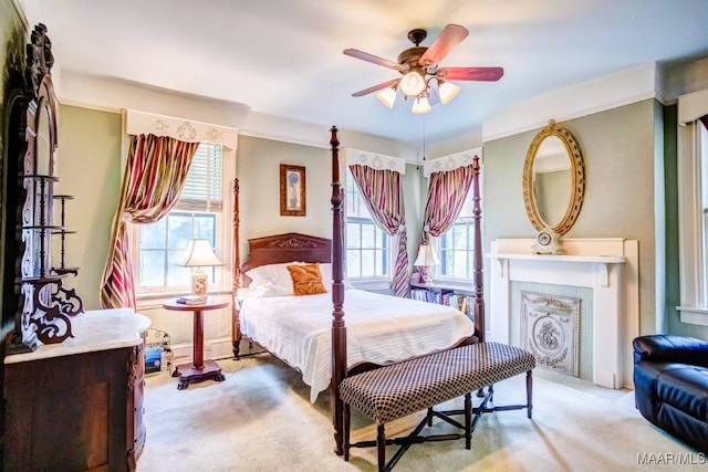 carpeted bedroom featuring ceiling fan and multiple windows